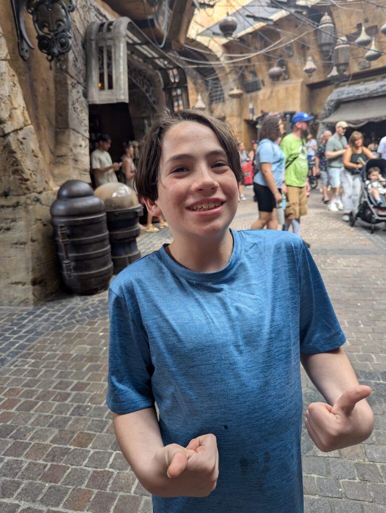 Boy living with epilepsy smiles and gives a thumbs up at Disney’s Hollywood Studios during Epilepsy Awareness Day at Walt Disney World.